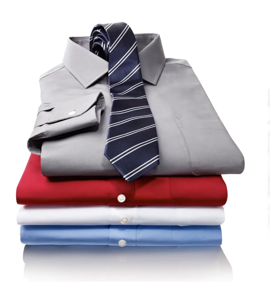 Folded dress shirts and a tie, stacked, directed product photography
